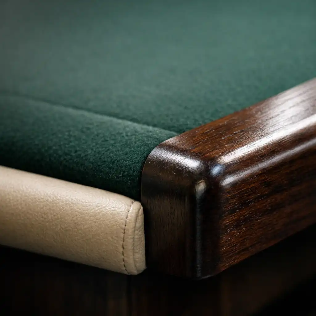 Macro view of a premium poker table edge showing dark timber meeting deep green felt